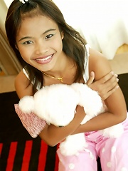 Thai Teen Tussinee plays with a teddy bear in bed